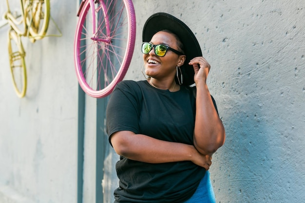 Closeup portrait stylish young African American girl with curly hair in fashionable sunglasses in urban with copy space and place for advertising summer hipster photos with instagram style