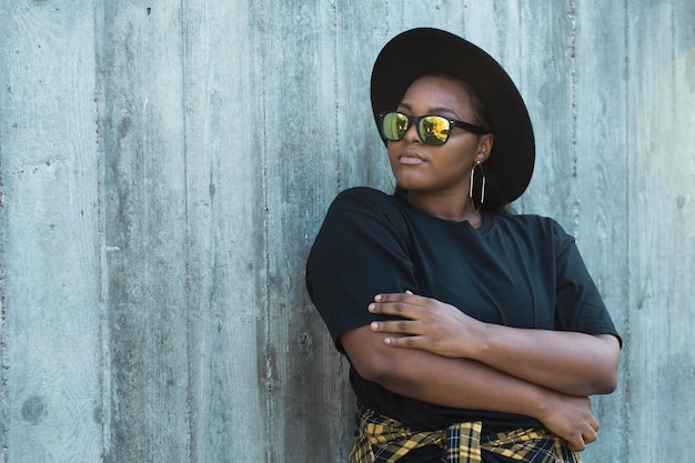 Closeup portrait stylish young African American girl with curly hair in fashionable sunglasses in urban with copy space and place for advertising summer hipster photos with instagram style