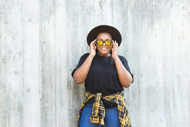 Closeup portrait of stylish young african american girl with curly hair in fashionable sunglasses in