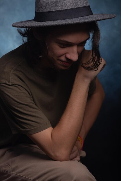 Closeup portrait of thoughtful young man wearing gray colored hat