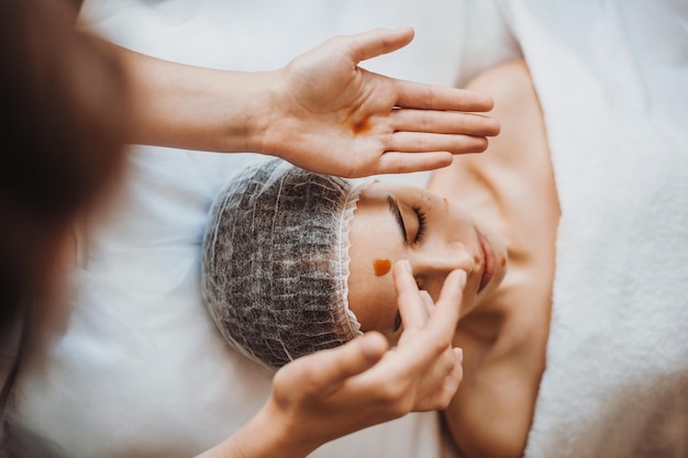 Closeup portrait of a woman receiving nourishing oil massage treatment in spa salon salon facial ski