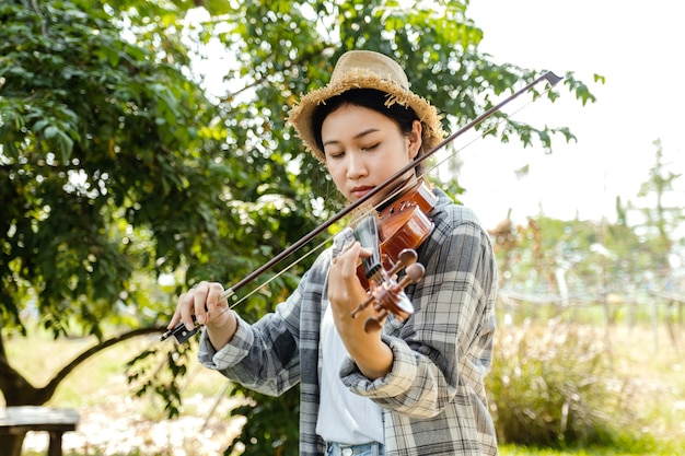 Closeup portrait of Young Asia woman music violinist play the violin relax in the garden