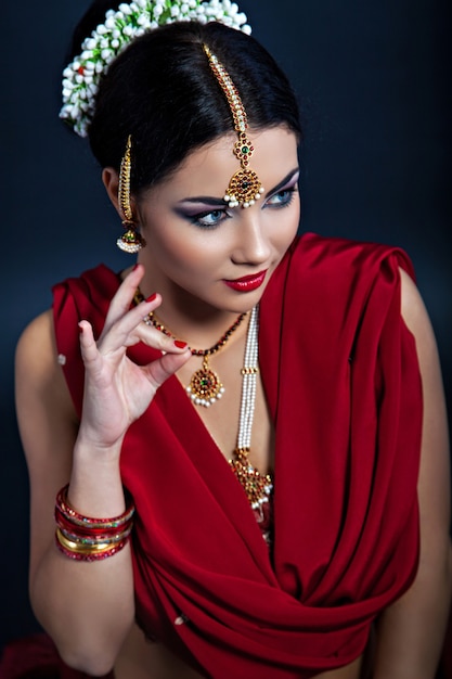 Closeup portrait of young beautiful woman in indian style, traditional finger sign