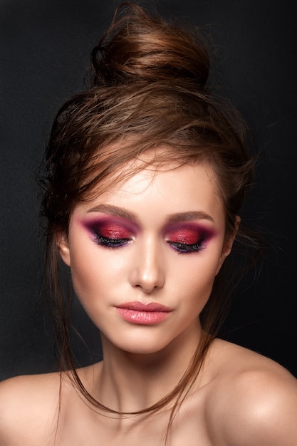 Closeup portrait of young beautiful woman with bright pink smokey eyes modern summer make up