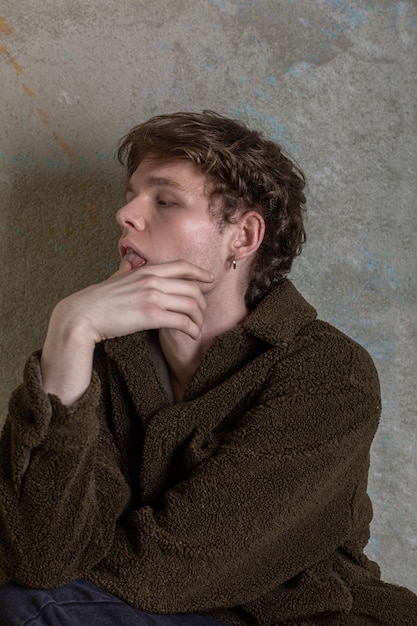 Closeup portrait of a young caucasian cute man expressively touching his tongue