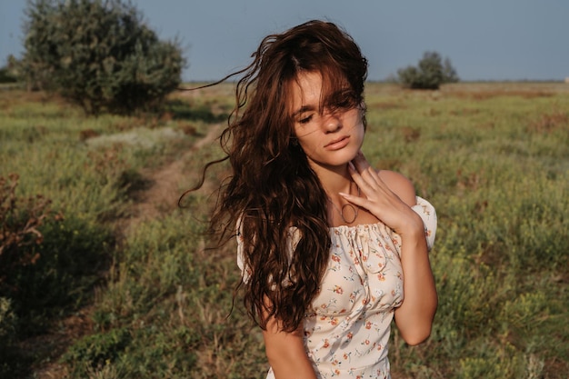 Closeup Portrait of a young Caucasian woman among the priors in a picturesque steppe boundless landscape Autumn or summer