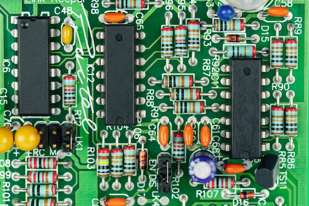 Photo closeup of a printed circuit board with components such as resistors and integrated circuits