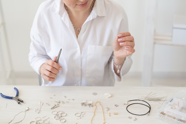 Closeup of professional jewelry designer making handmade jewelry in studio workshop closeup fashion