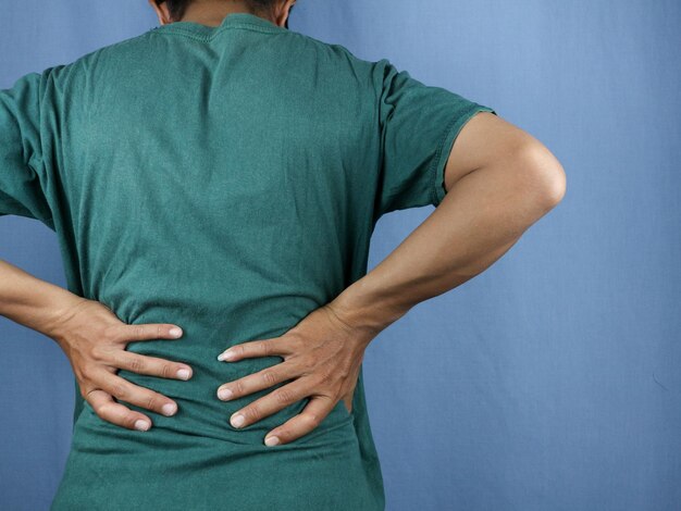 Closeup rear view of man39s hand touching back pain low back pain concept