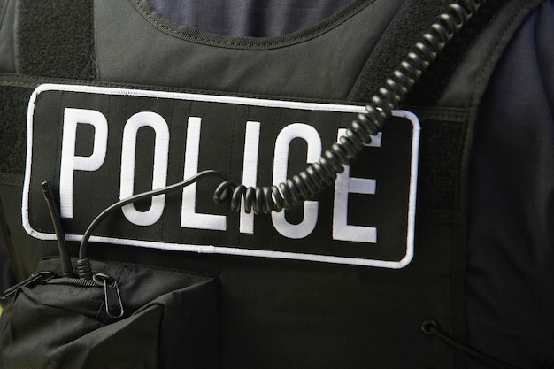 Photo closeup rear view of policemans sign and cord on protective jacket