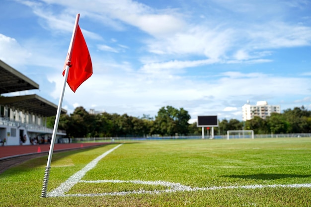 Closeup red flag in a football ground corner with bright blue sky