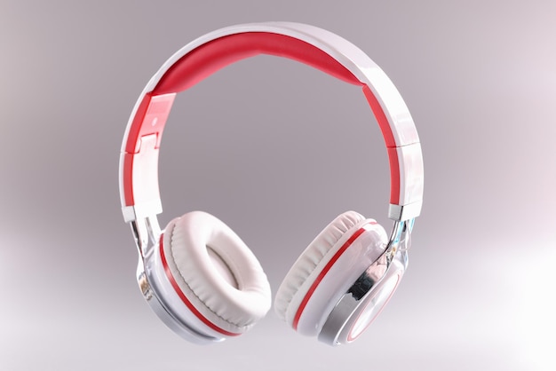 Closeup of red and white wireless headphones on gray background