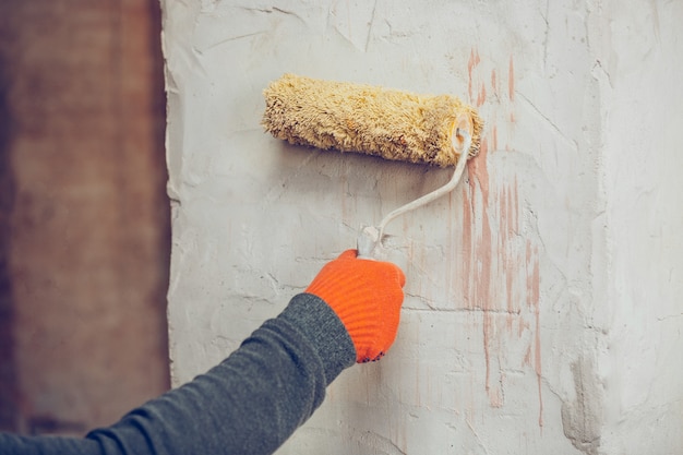 Closeup of repairman in uniform, professional builder working using construction equipment. Process of building, apartment renovation, repairing, building. Sawing, connecting, cutting, preparing.