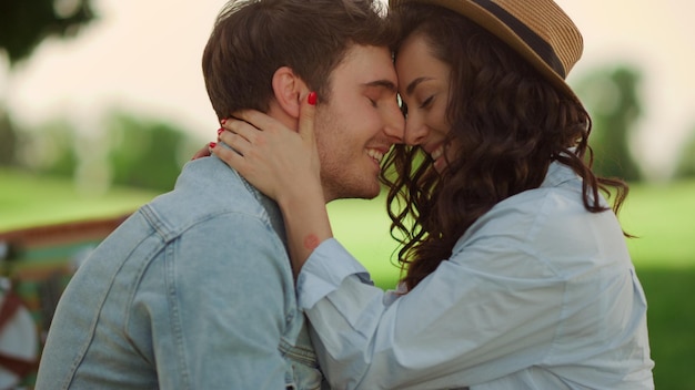 Closeup romantic people hugging on romantic dating in park Portrait of happy man and woman spending time at summer outdoors Love couple showing tenderness on picnic