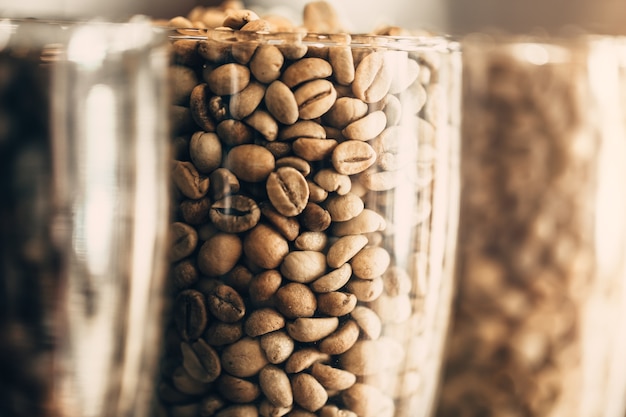 closeup rosted coffee bean. arabica coffee bean in clear glass cafe decoration.