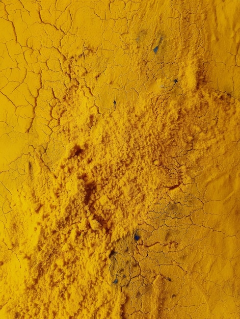 Photo a closeup of a rough yellow surface with visible cracks the rough texture of the ground powder or a dusty substance