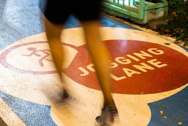 Closeup of running feet of a male in athletic clothes practicing run on a jogging lane in an indoor studio