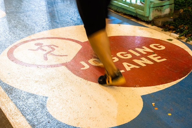 Closeup of running feet of a male in athletic clothes practicing run on a jogging lane in an indoor studio