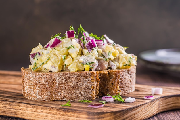 Closeup of rye bread sandwich with swedish salad on wooden board