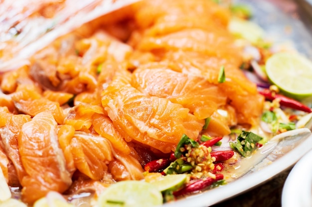 Closeup of Salmon Spicy Salad with herb recipe, thai street food market