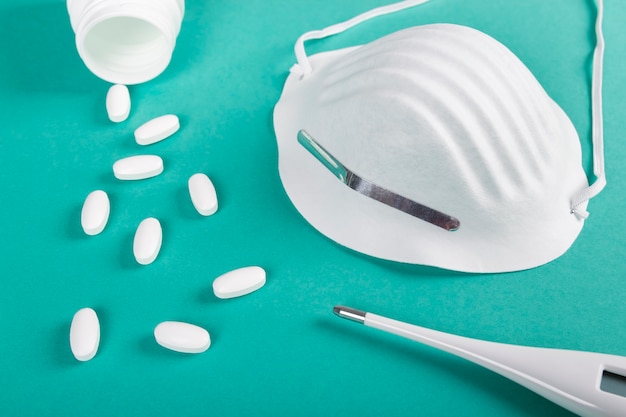 Closeup of sanitary mask, pills and thermometer to prevent a disease