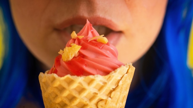 Photo closeup of sensual female lips with a waffle cone of pink ice cream a cropped photo of a woman with blue hair enjoys eating pink gelato on a hot summer day macro happy sweet tooth