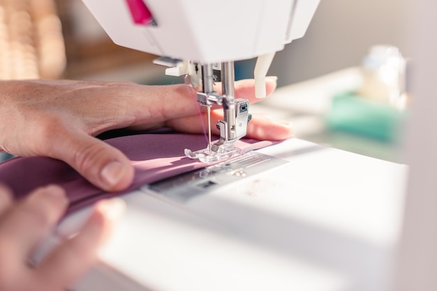 Closeup of sewing machine needle sewing a piece of fabric