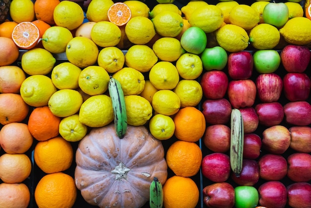 Closeup of a shop window with selected fresh fruits apples oranges coconuts pineapples for a healthy lifestyle