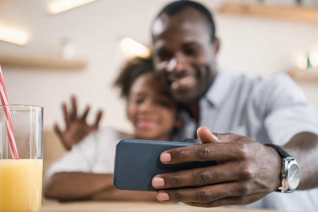 Closeup shot of africanamerican father and daughter taking selfie