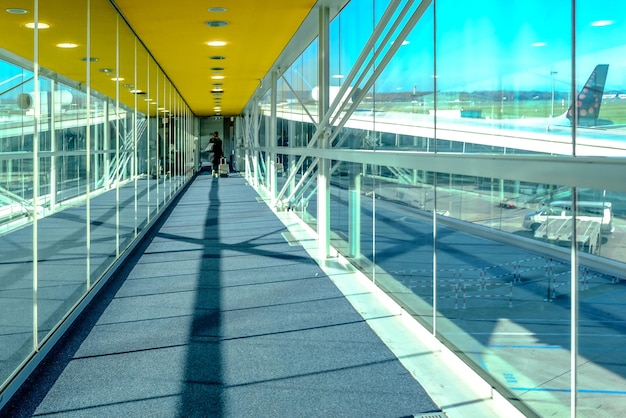 Closeup shot of an airport boarding corridor with planes seen in the background