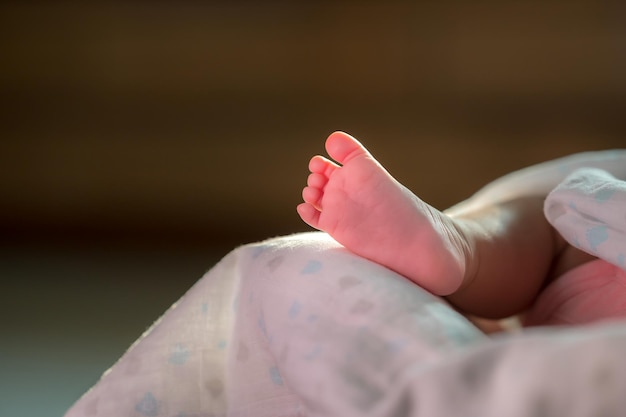 Closeup shot of baby foot in bed in the moring sunlight