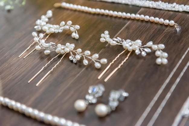 Closeup shot of beautiful white hair accessories for the bride on a wooden surface