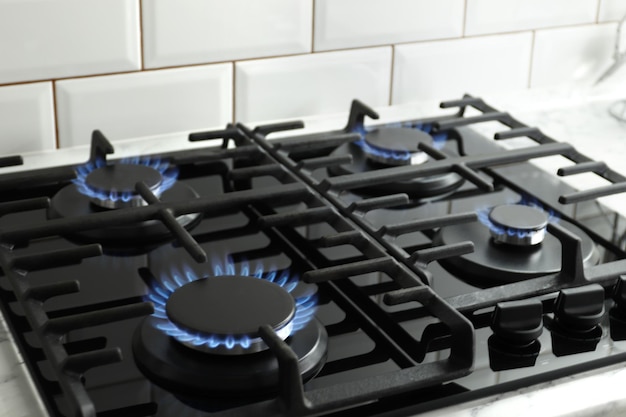 Closeup shot of blue fire from domestic kitchen stove top. Gas cooker with burning flames of propane gas. Industrial resources and economy concept.