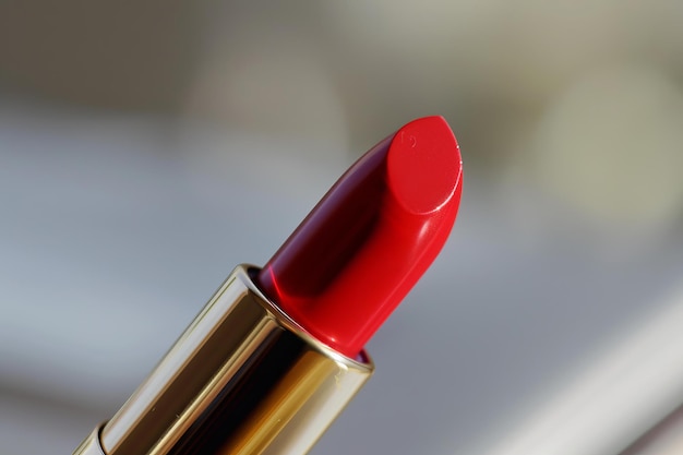 Closeup shot of a bright red lipstick in a luxurious gold tube symbol of elegance and beauty