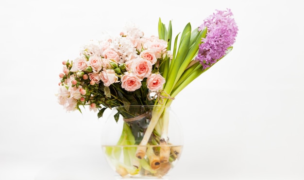 Closeup shot of colorful flowers in glass vase against white