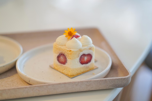 Closeup shot of delicious cream cake with strawberries on a wooden table