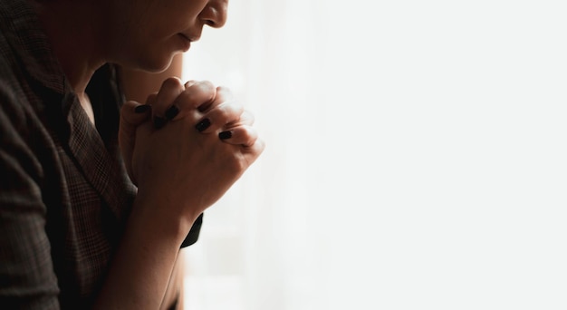 Closeup shot of a female praying at home christian concept