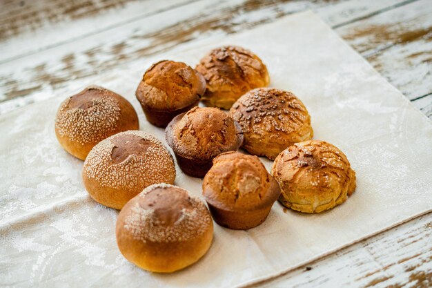 Closeup shot of freshly baked buns cupcakes and cookies on a wooden surface