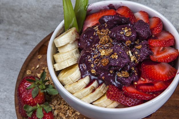 Closeup shot of a fruit salad with bananas, strawberries, pecan and acai cream