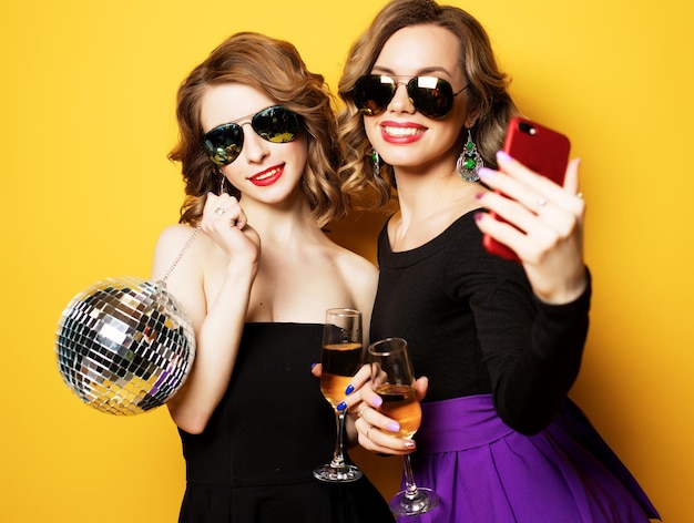 Closeup shot of group of laughing girls having party take selfie with smartphone