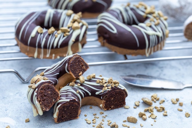 Closeup shot of a halved appetizing chocolate-covered raw donuts with nuts sprinkles