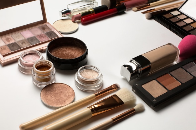 Closeup shot of highlighters, cream eyeshadows and mineral makeup palettes on a white background. Space for text