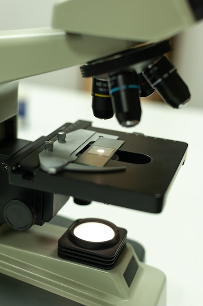 Photo closeup shot of microscope with metal lens at laboratory