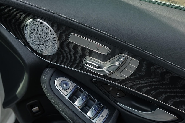 Closeup shot of a modern car door handle interior details with controls and adjustments