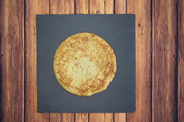 Closeup shot of a round omelet on a wooden table