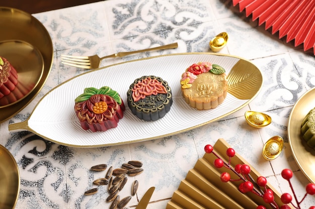 Closeup shot of small moon cakes served for Chinese ceremony on the white plate with golden edges