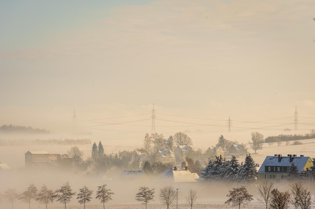 Closeup shot of a small town covered in fog in winter