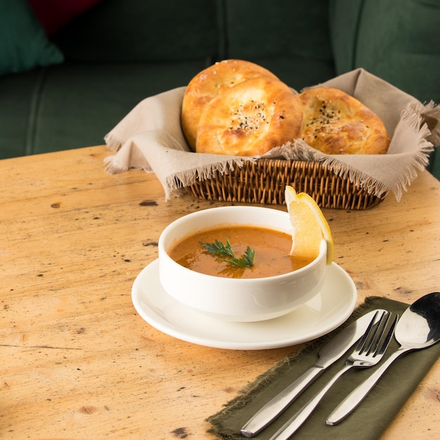 Closeup shot of a soup and appetizers near basket of breads