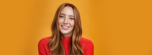 Closeup shot of tender gentle and cute redhead cutie with long natural hairstyle smiling joyfully wi