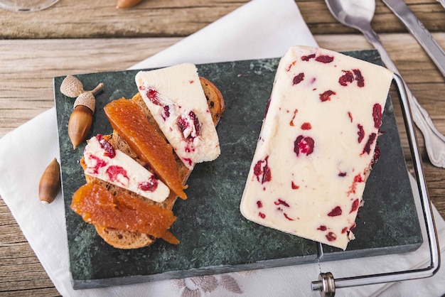 A closeup shot of Wensleydale cheese with cranberries and wine